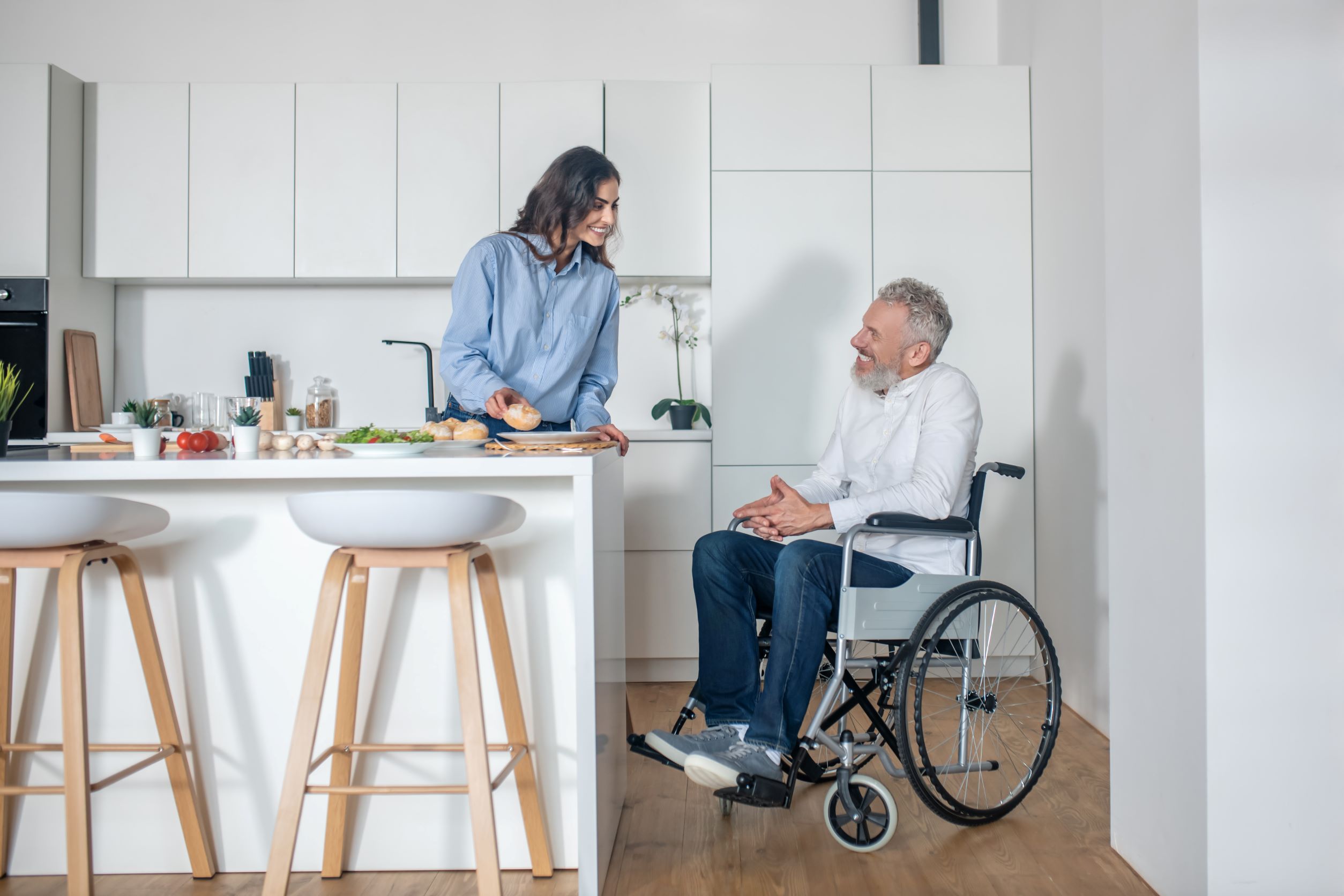 NDIS participant in a wheelchair at home with a support worker